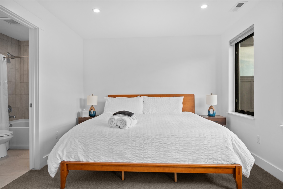 Spacious king bedroom with en-suite bath and modern furnishings.