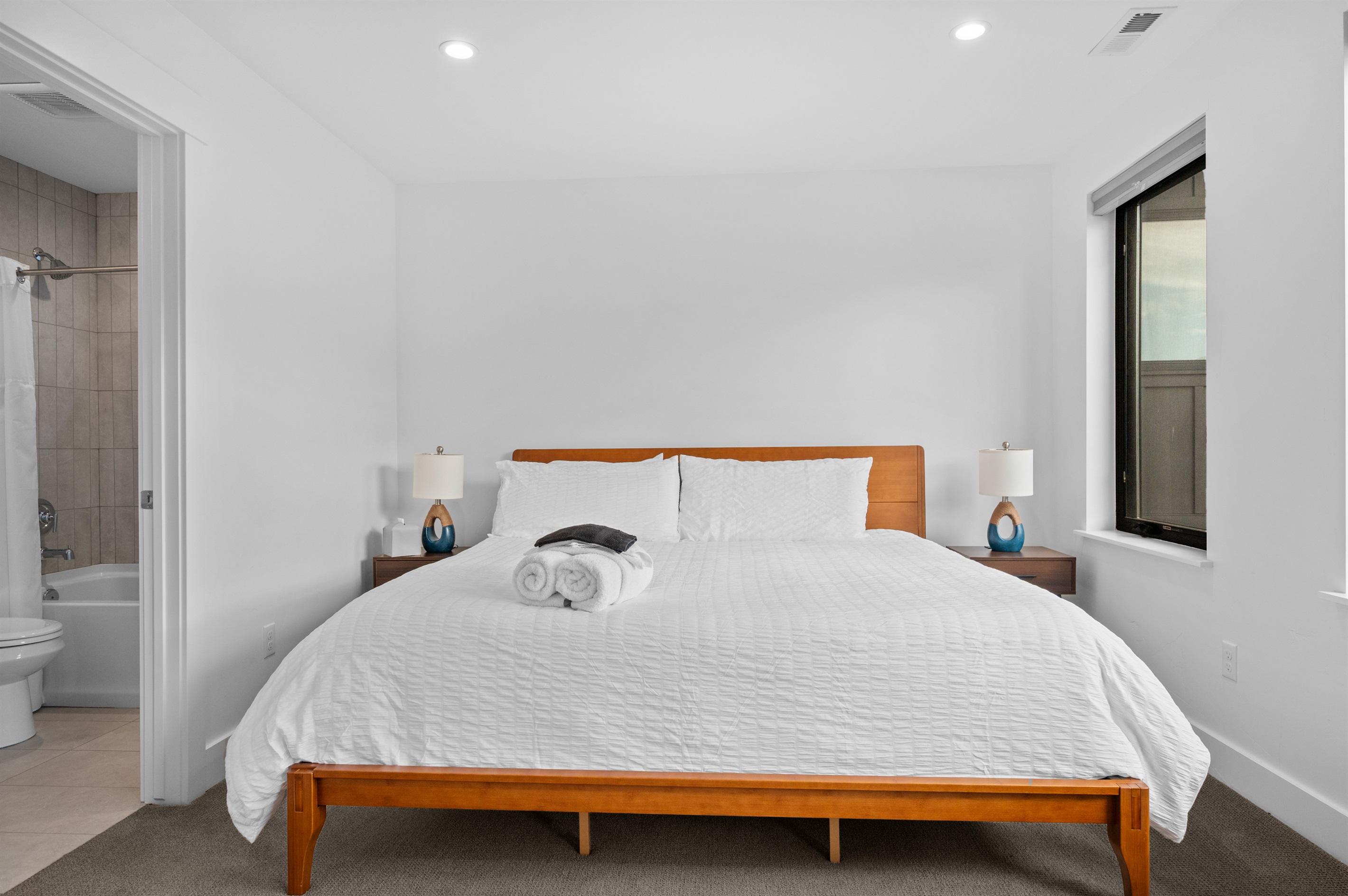 Spacious king bedroom with en-suite bath and modern furnishings.