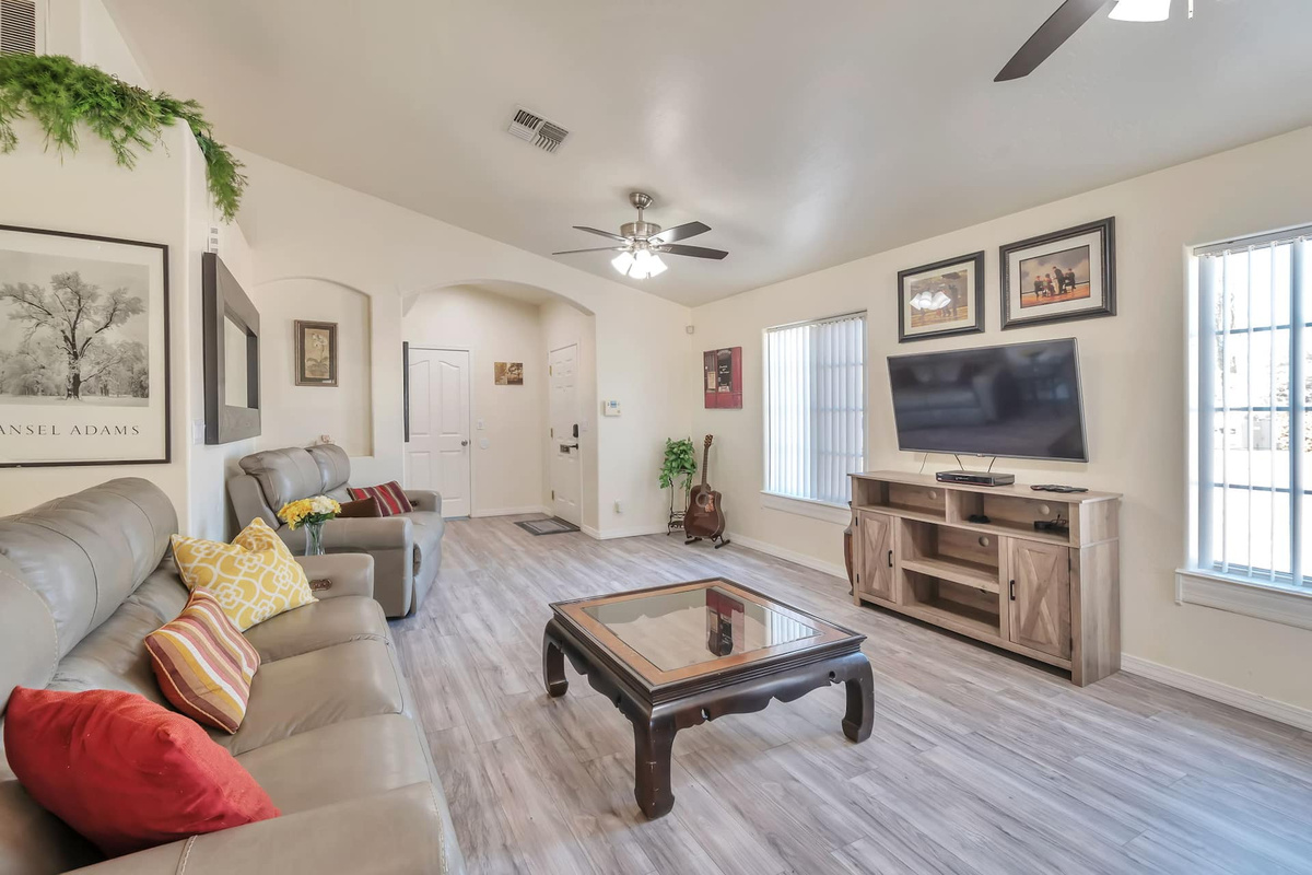 Movie nights done right — big flat-screen TV, plush leather seating, and a guitar in the corner if you're feeling musical