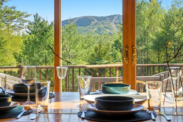 Dine against a backdrop of rolling mountains and lush greenery just beyond the deck.