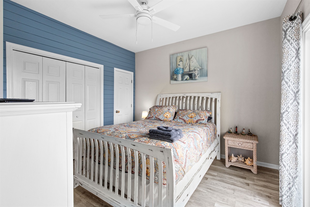 Comfortable queen bed with coastal d&eacute;cor and soft lighting