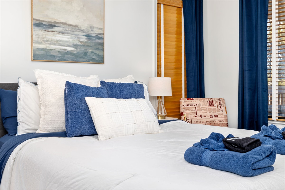 Charming Bedroom 1: Unwind in style with plush pillows and warm lighting for peaceful nights!