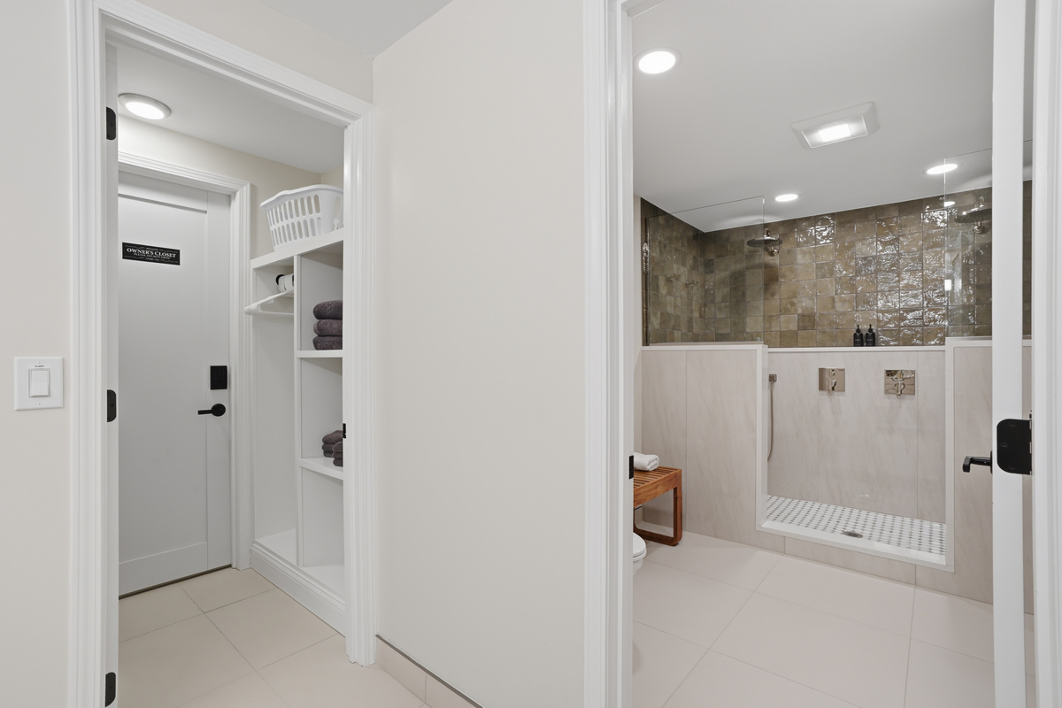 Clean, modern interior with minimalist design, built-in storage, and a spa-style bathroom with walk-in shower. Bright, neutral tones and recessed lighting create a calm, upscale, hotel-like feel.