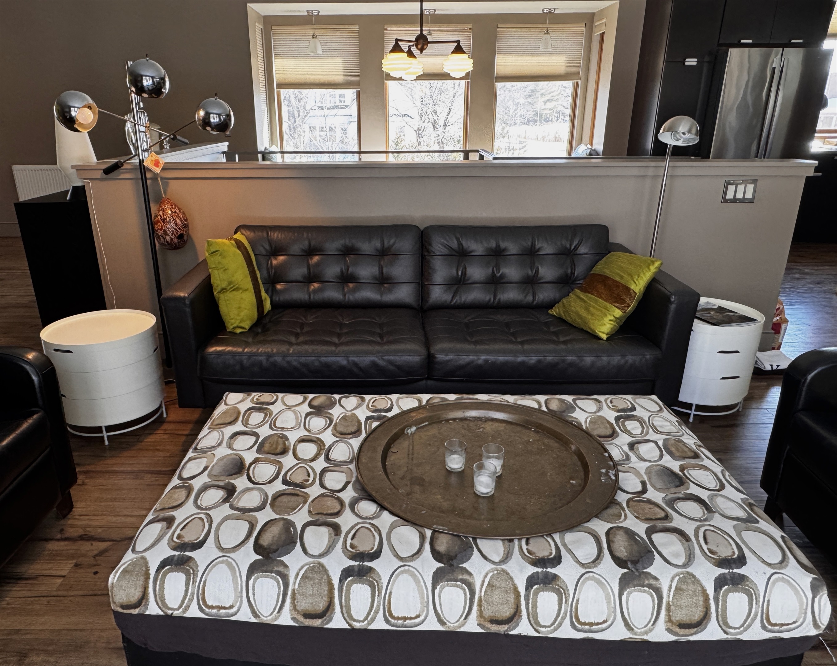 The main level sitting area features modern leather seating and intentional designer touches. Positioned directly across from a wall of windows, this space offers uninterrupted views of the 33ft deck and the quiet Acadia National Park border.