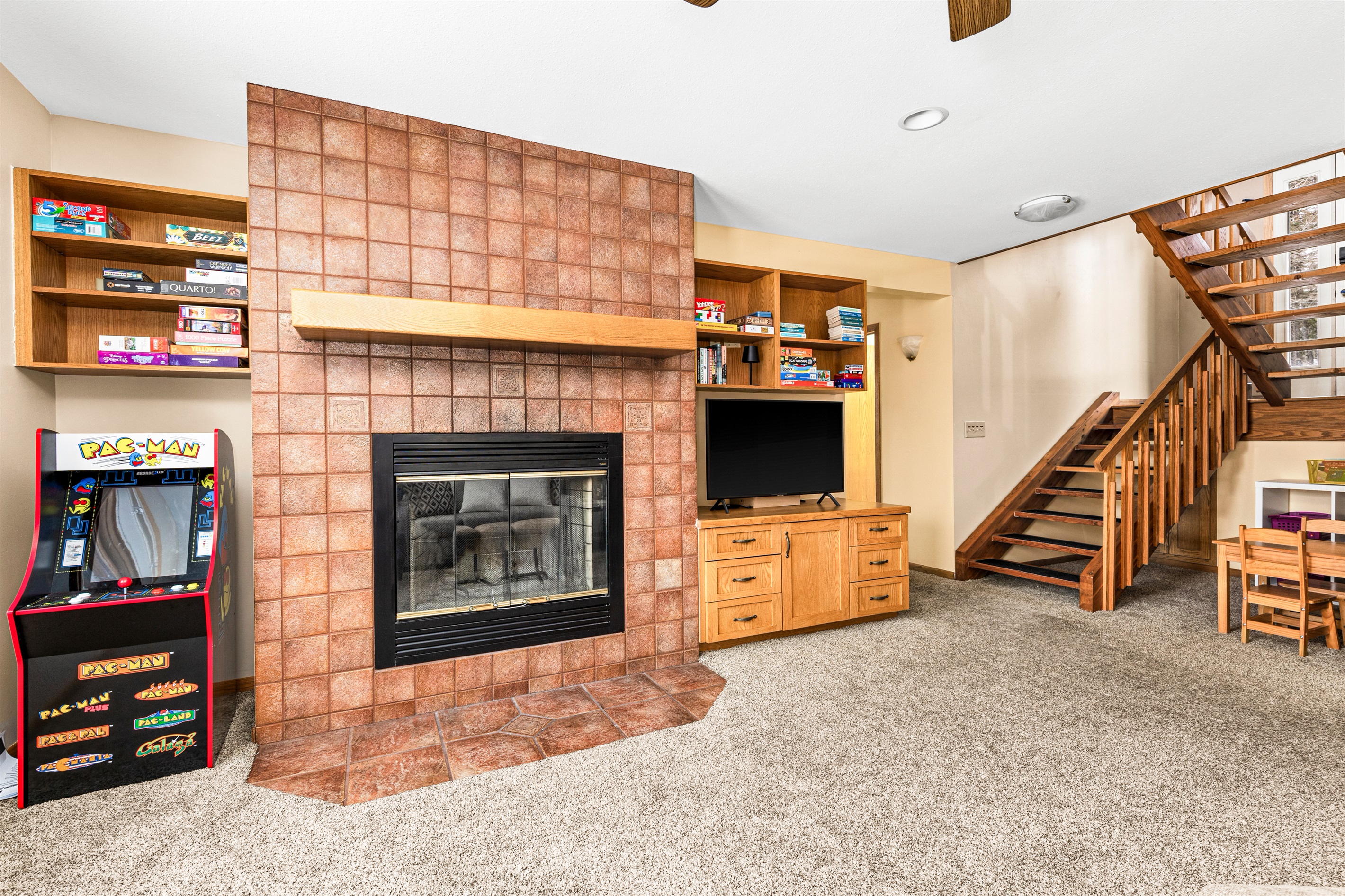 Basement living room with kids size arcade is a perfect space for little ones to play.
