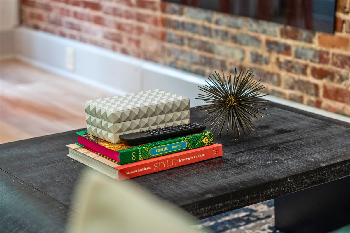 A charming coffee table display with colorful books and decor adds a pop of personality to this inviting space.