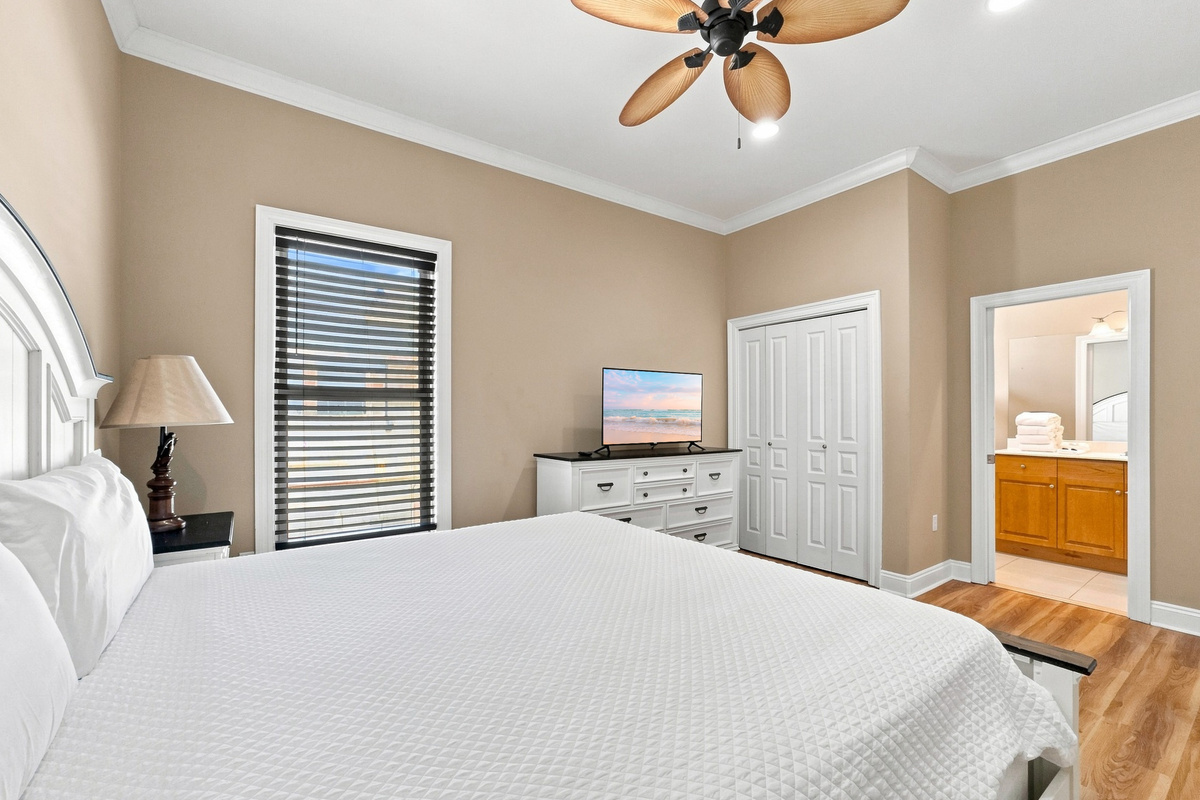 Comfortable guest bedroom with ceiling fan and ample natural light