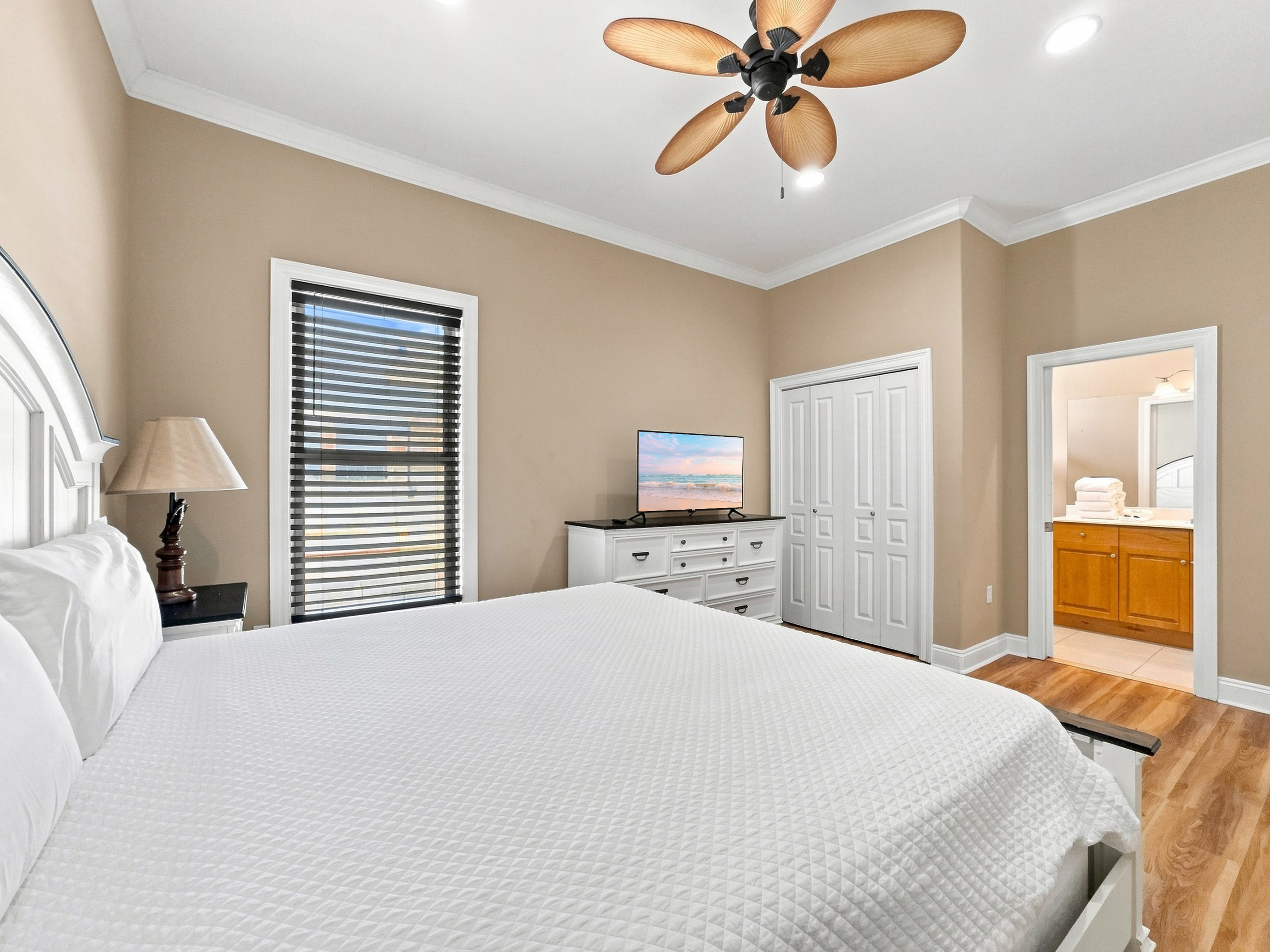 Comfortable guest bedroom with ceiling fan and ample natural light