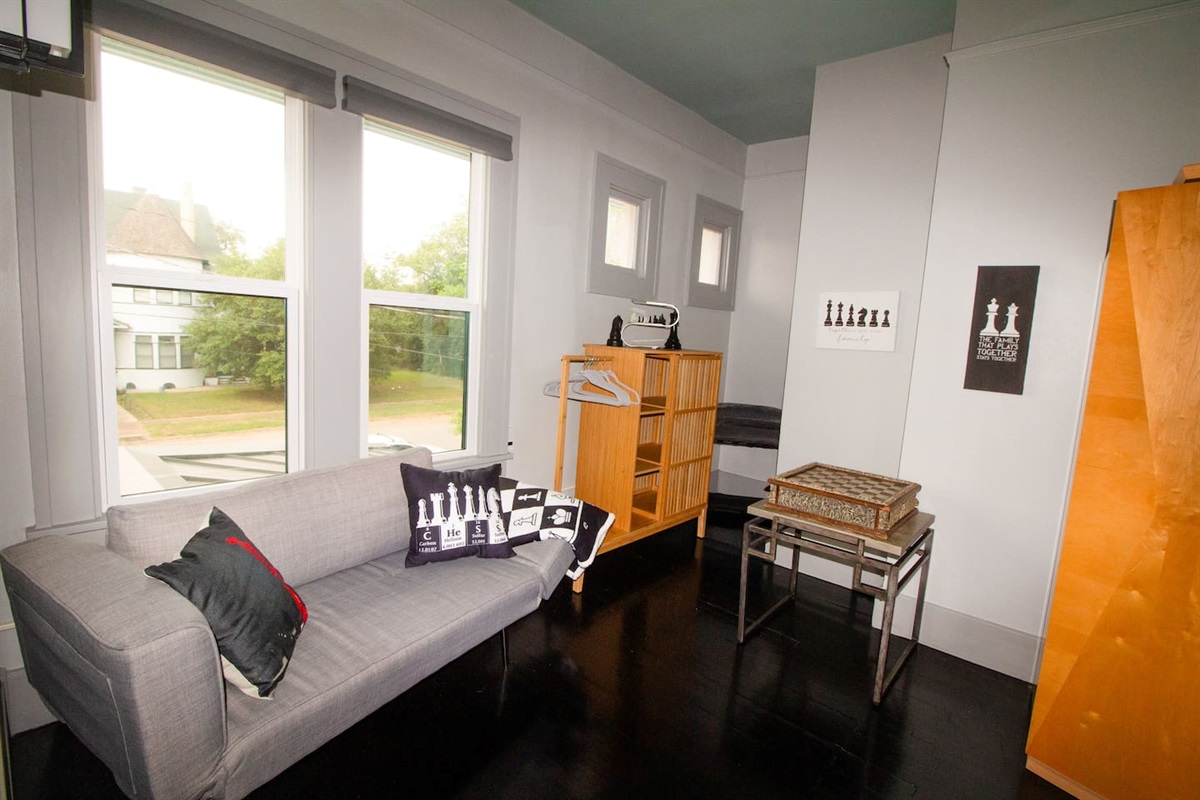 Sitting area is a quiet spot for playing Chess, a glass of wine, watching old movies, or playing video games. It is a flexible love seat that can hold a small child. Storage for personal items is generous for longer stays. 