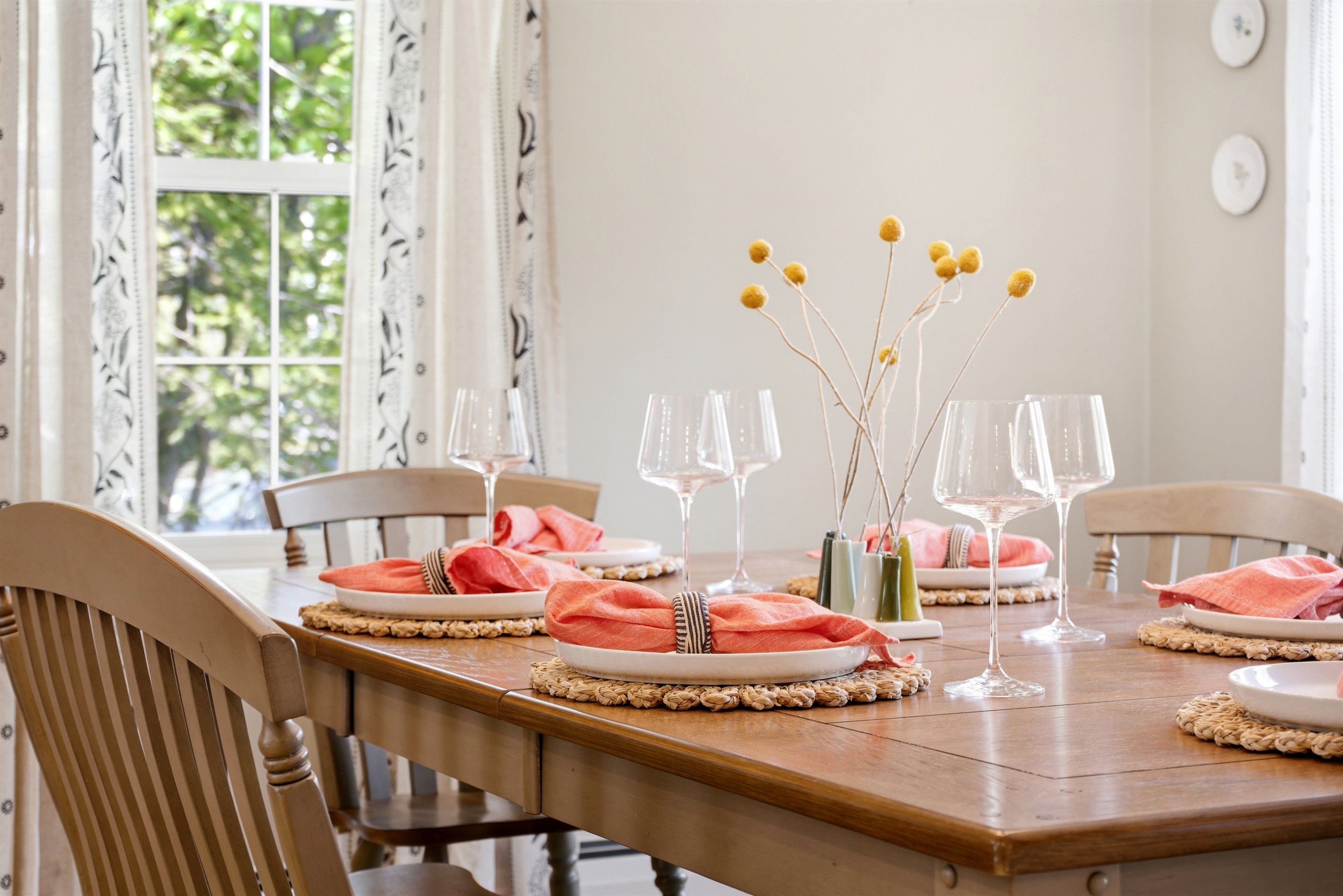 An airy dining room bathed in natural light, featuring a thoughtfully set table with cutlery that highlights both comfort and effortless elegance.