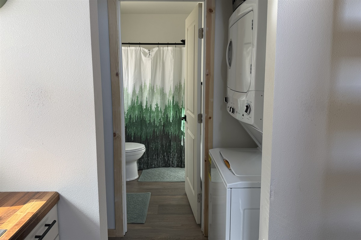 Laundry room with stacked washer / dryer located just outside bathroom.