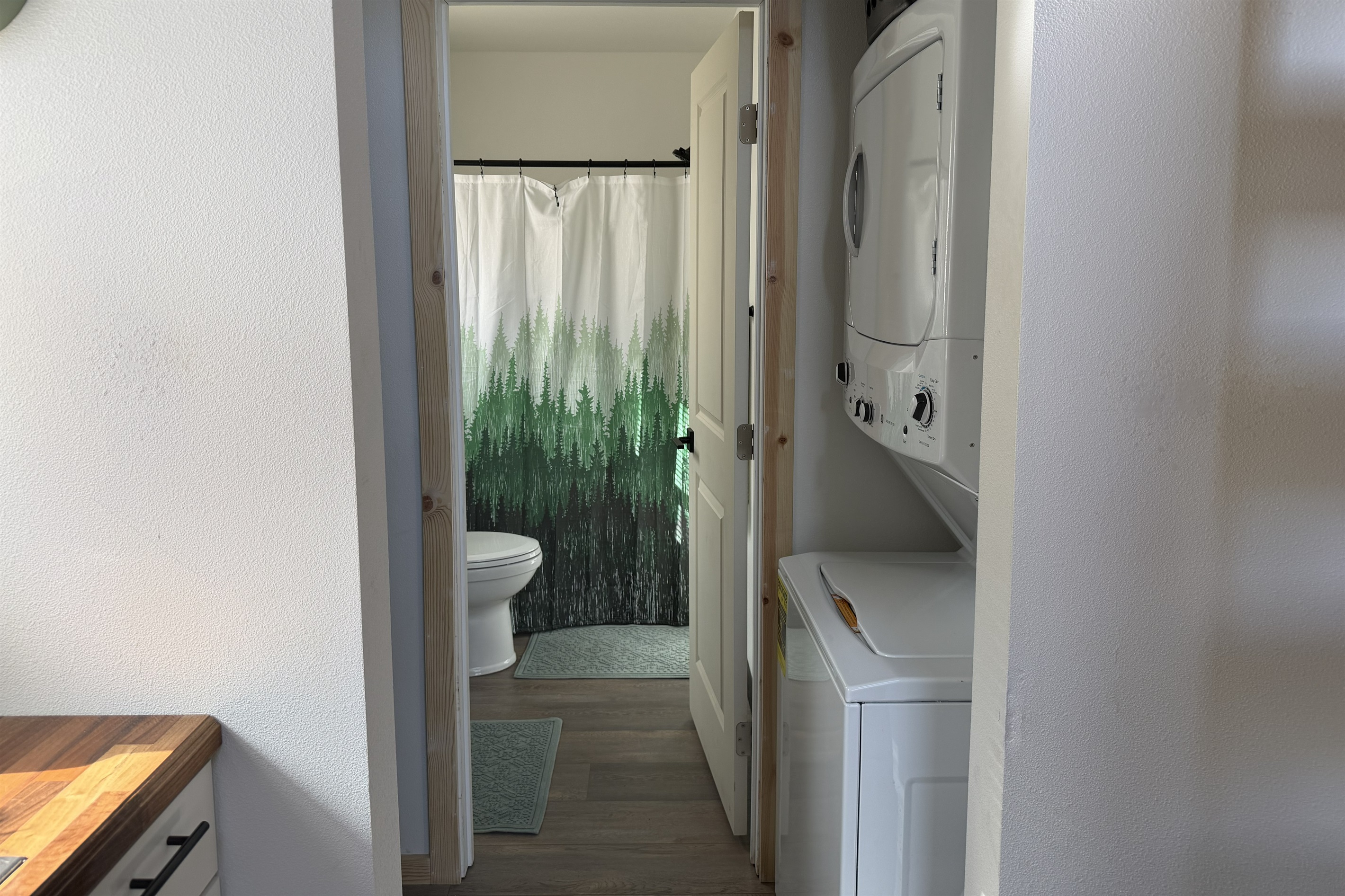 Laundry room with stacked washer / dryer located just outside bathroom.