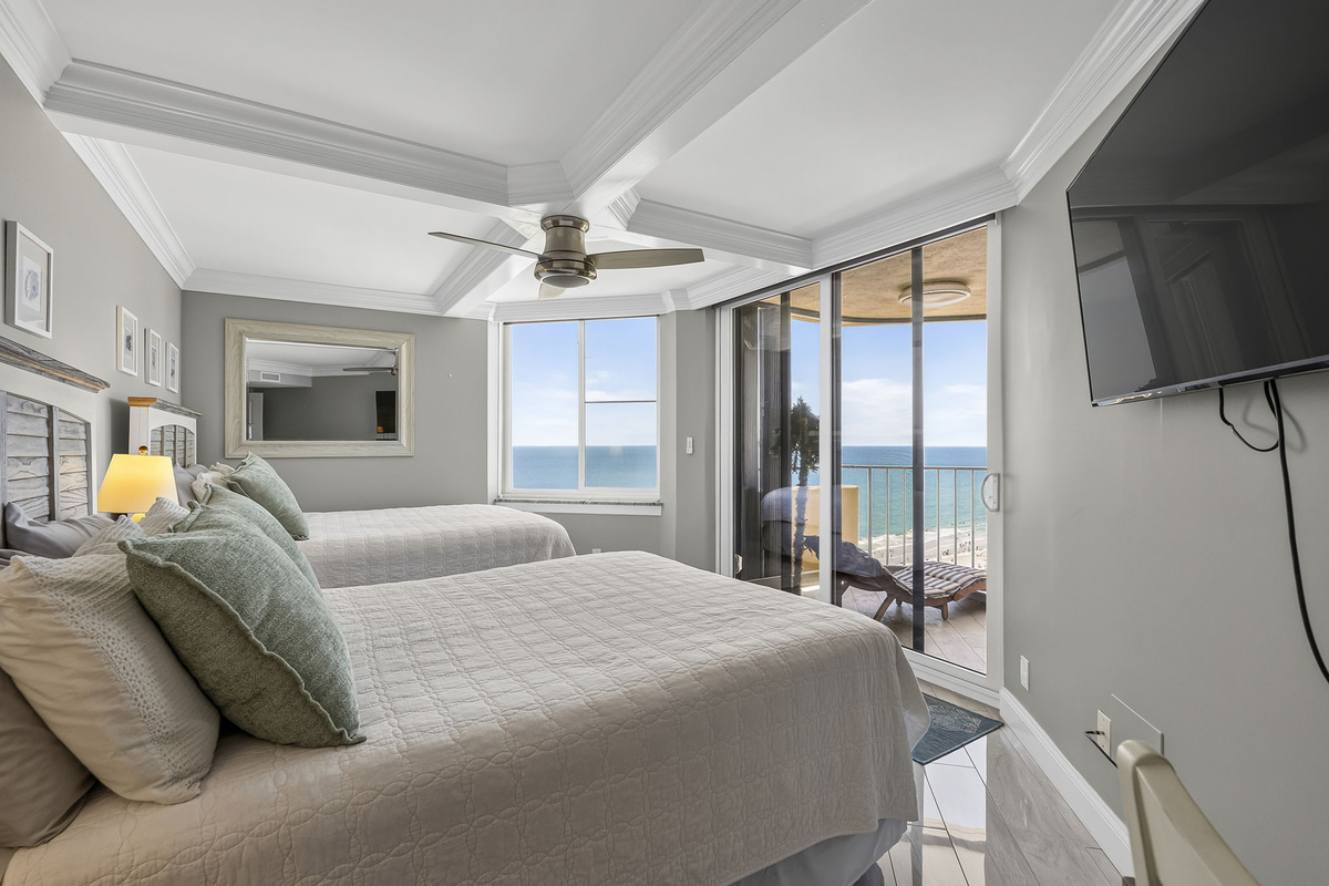 Guest bedroom with two full size beds and balcony access
