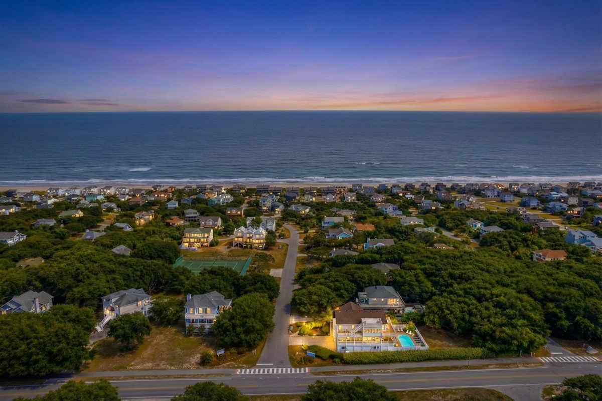 An aerial drone shot highlighting Southside Pearl's location, showing the short walk to the beach access and proximity to community tennis courts.