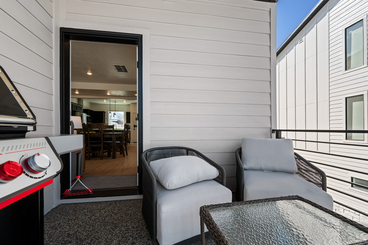 A covered balcony seating area creates a comfortable spot to enjoy fresh air in any season.
