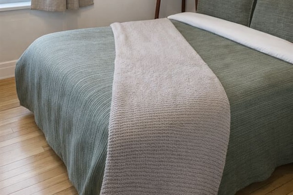 Bedroom detail with soft linens and comfortable mattress.