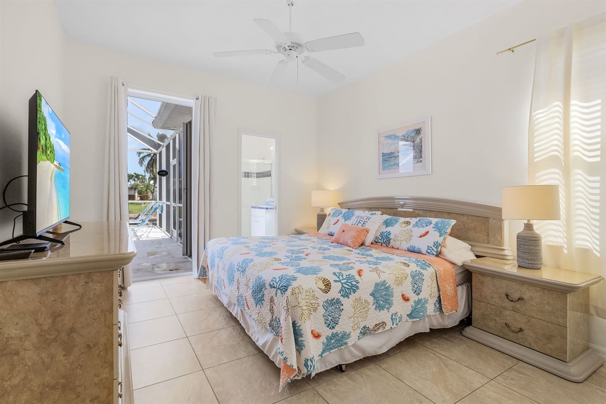 1st Guest bedroom with a king-size bed, TV, private ensuite bathroom, and direct access to the pool and lanai area!