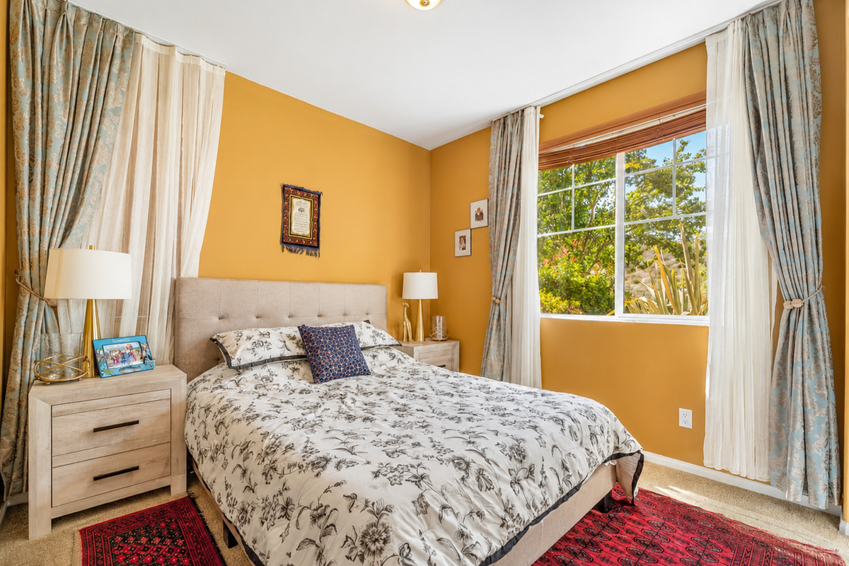 Warm bedroom with soft bedding, sunny windows, and a calm place to rest.