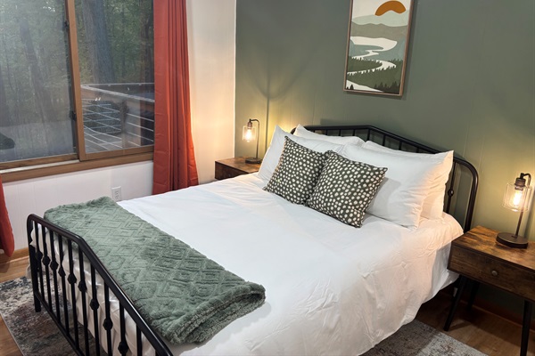 Enjoy restful nights in this Queen bedroom with calming views of the surrounding forest.