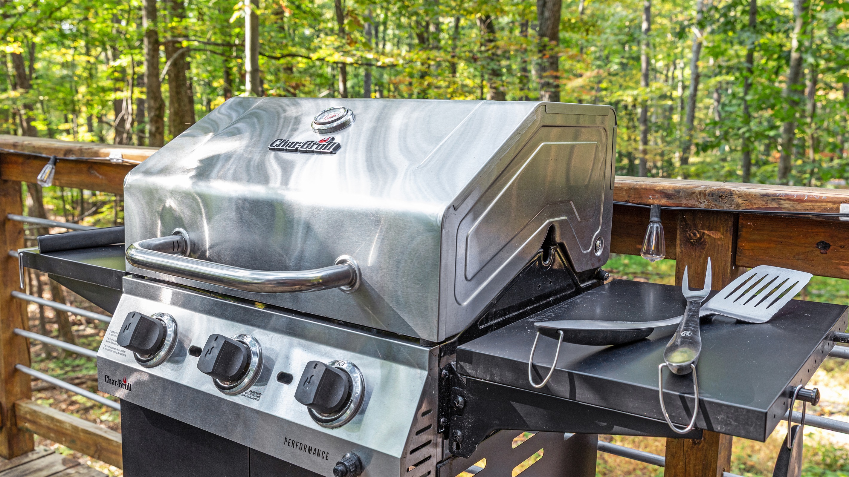 Fire up the grill! Fully stocked BBQ utensils and a beautiful view of the woods make for the perfect meal on the deck