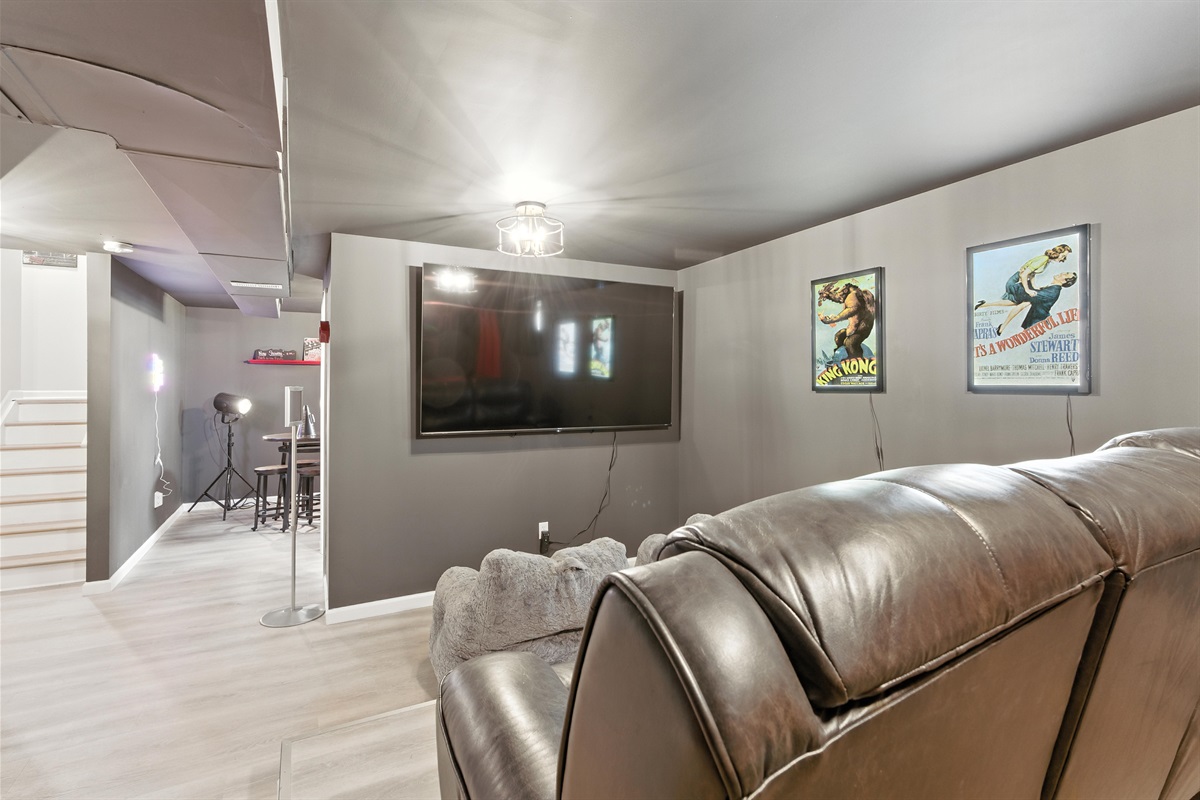 Private movie room featuring 85 inch smart TV and cozy seating