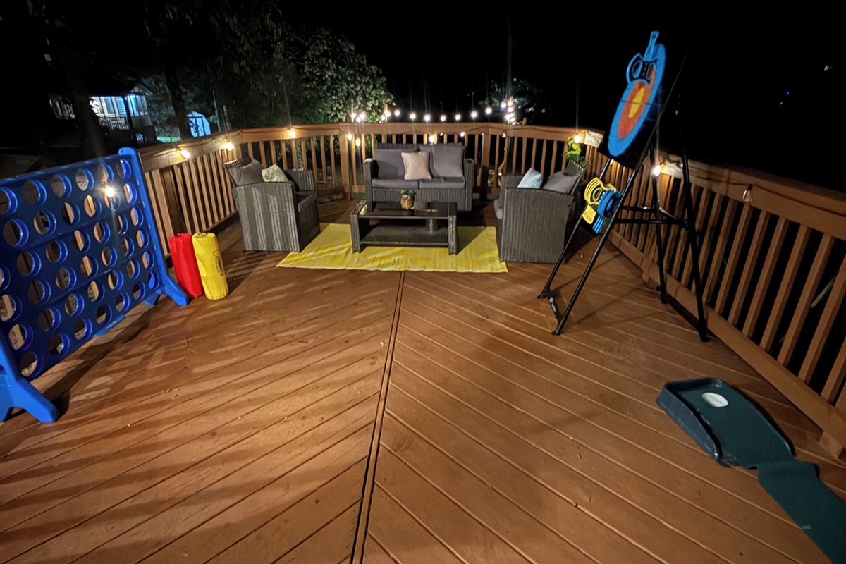 Cushioned seating, string lights, and oversized Connect 4 make this deck a favorite for evening hangouts. 