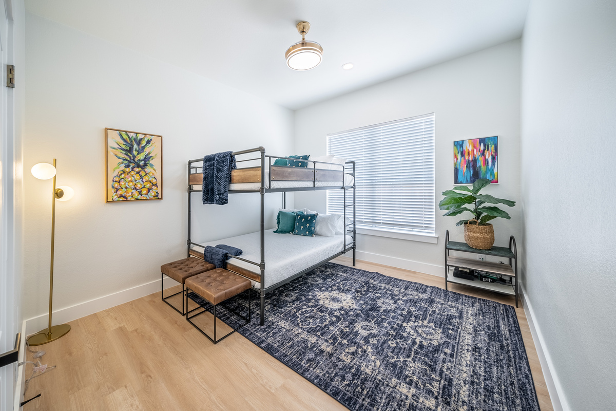 Cozy bunk room featuring a patterned rug and warm wood accents.