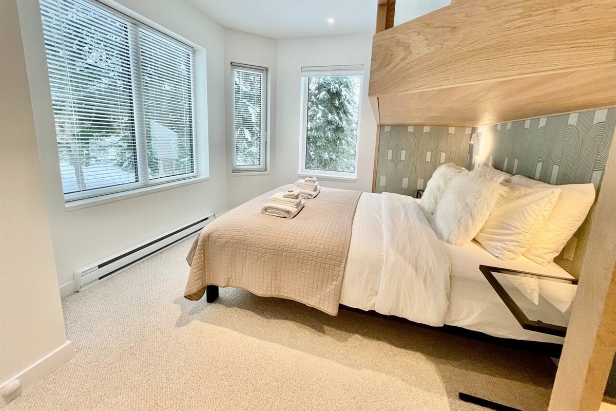 Bedroom#3 on 2nd floor has surround windows that immerse you in the scenic backdrop of Whistler mountain & glacier fed Fitzsimmons Creek. It’s like sleeping in Winter Wonderland. Sleeps up to 3 Adults:  Queen + built-in overhead adult size Twin XL