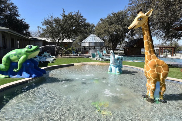 Kid splash pad located next to pool. 