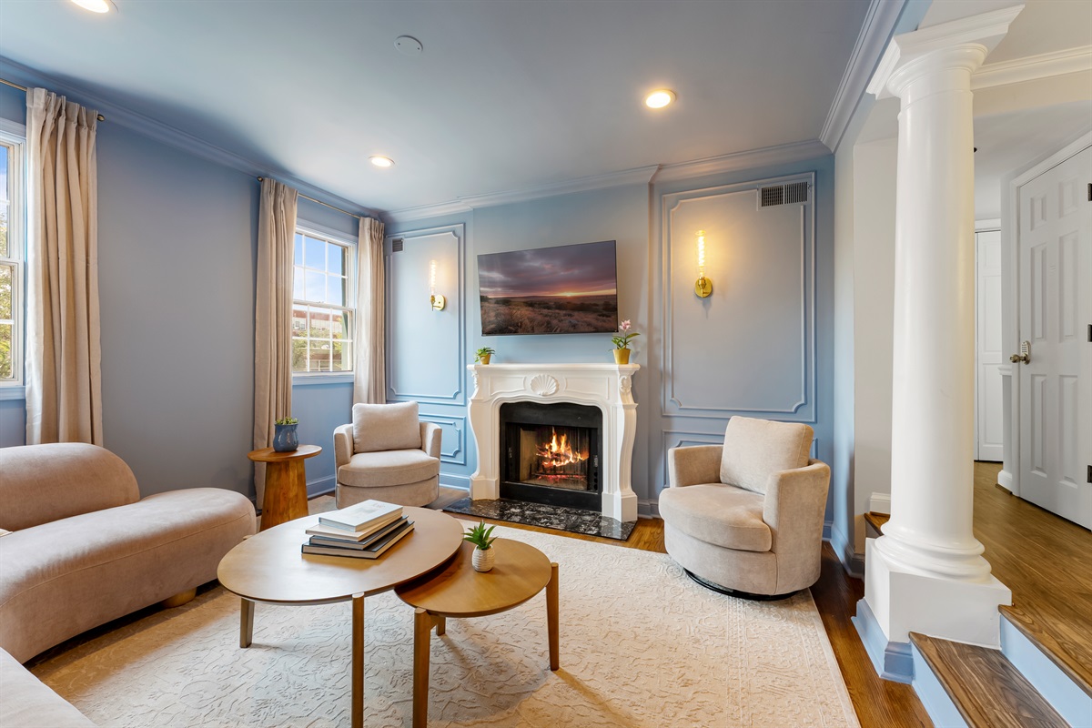 Elegant living room featuring a decorative fireplace, classic molding details, and inviting natural light