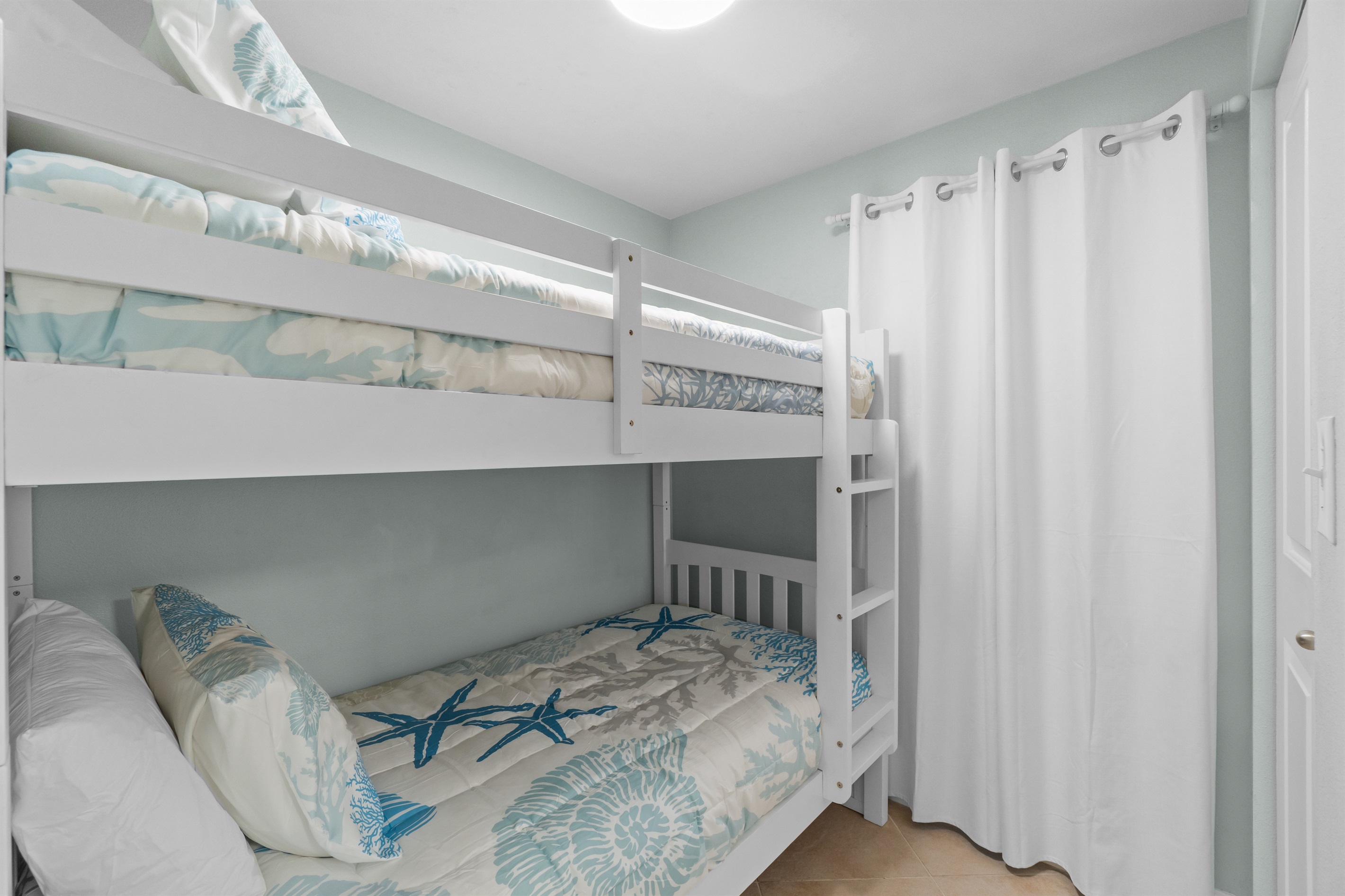 The guest bedroom makes the most of its small space with bunk beds and a small closet.