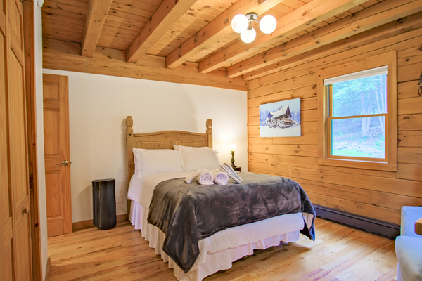 This first guest bedroom is equipped with a queen size bed, providing all the privacy you might need. This all-wood room creates the coziest feeling of a true cabin.