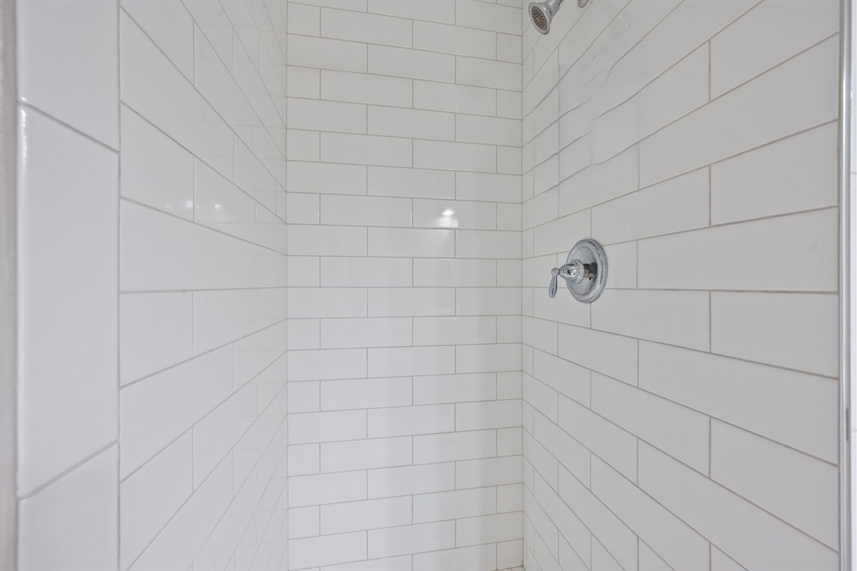 Freshly tiled walk-in shower with beachy, spa-like details for a relaxing rinse after the pool or ocean