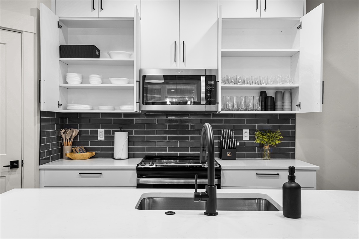 Stay organized in this modern kitchen featuring fully stocked glassware cabinets.