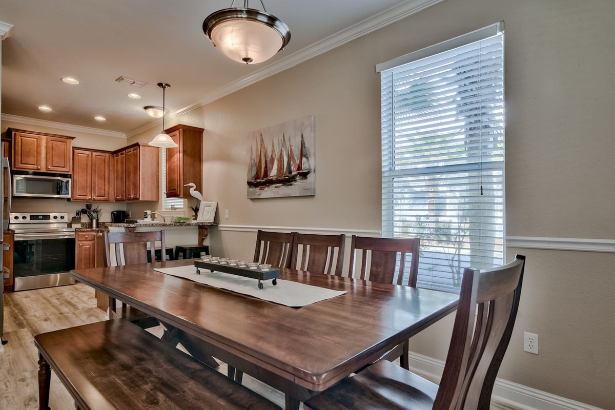 Spacious dining area featuring a large 8-9 seater coastal table, with a kitchen bar for two. 