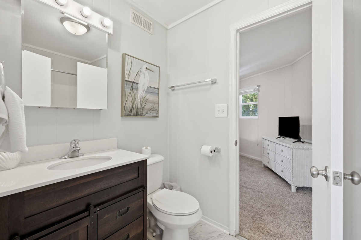 Updated full bathroom with a modern vanity, shower/tub combination, and convenient access from the bedroom
