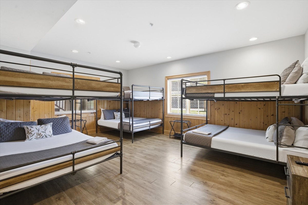 Step into the queen bunk room featuring three queen over queen bunks, creating a fun, spacious setup that comfortably brings your group together in one inviting space.
