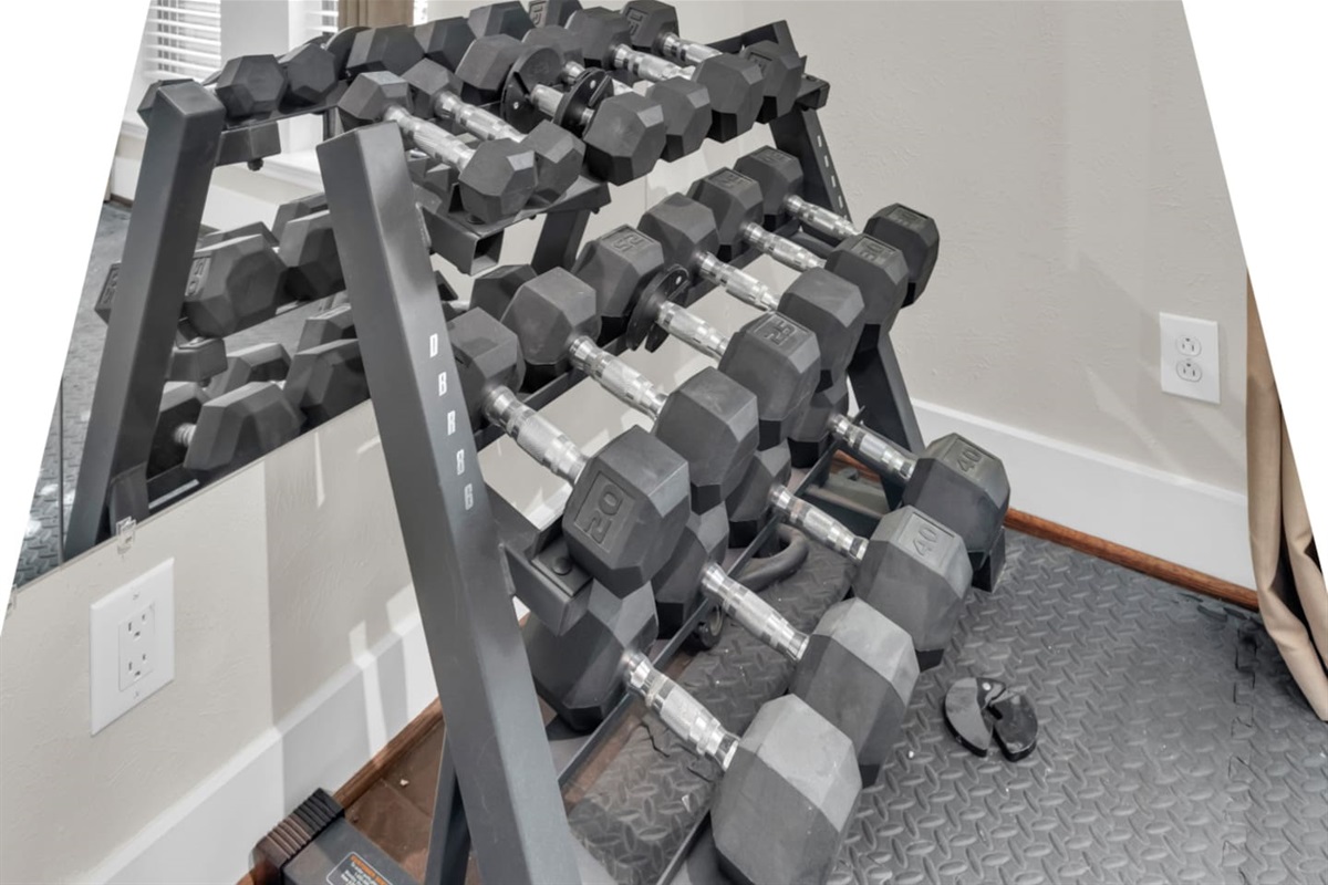 Dedicated private gym room featuring a full power rack, free weights, and functional training equipment, ideal for maintaining your fitness routine during your stay.