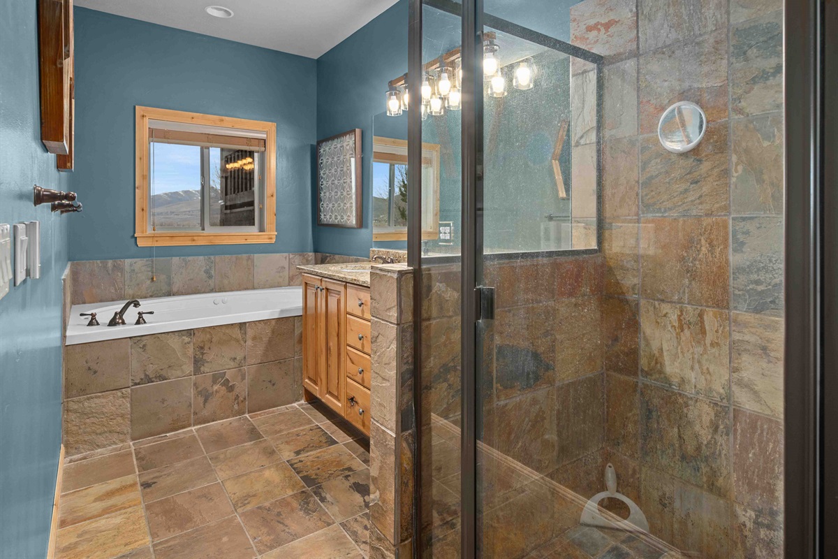 Beautiful bathroom with tiled walk-in glass shower and soaking tub.