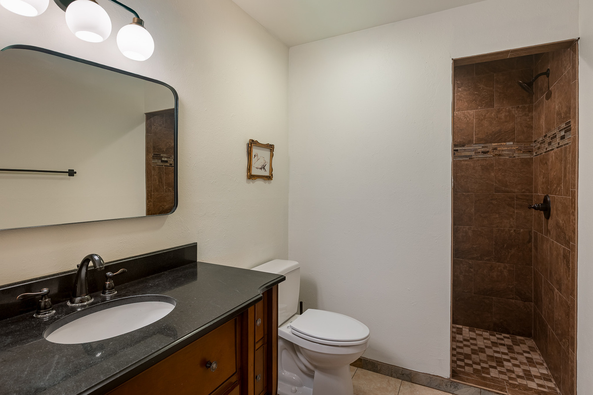 {Pool House Bathroom} A full bathroom with a walk-in shower sits just off the indoor pool for easy access between swims, workouts, and sauna sessions.