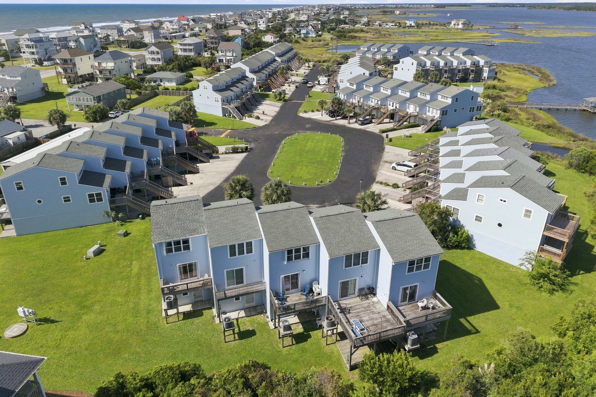 A wonderful overhead view showcasing the charming townhome cluster, winding roads, and surrounding coastal landscape.