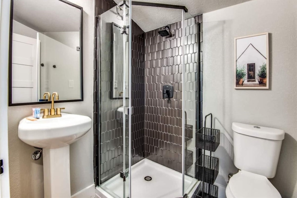 Walk-in shower, matte black fixtures, and frameless glass door. Stocked with shampoo, conditioner, and body soap.