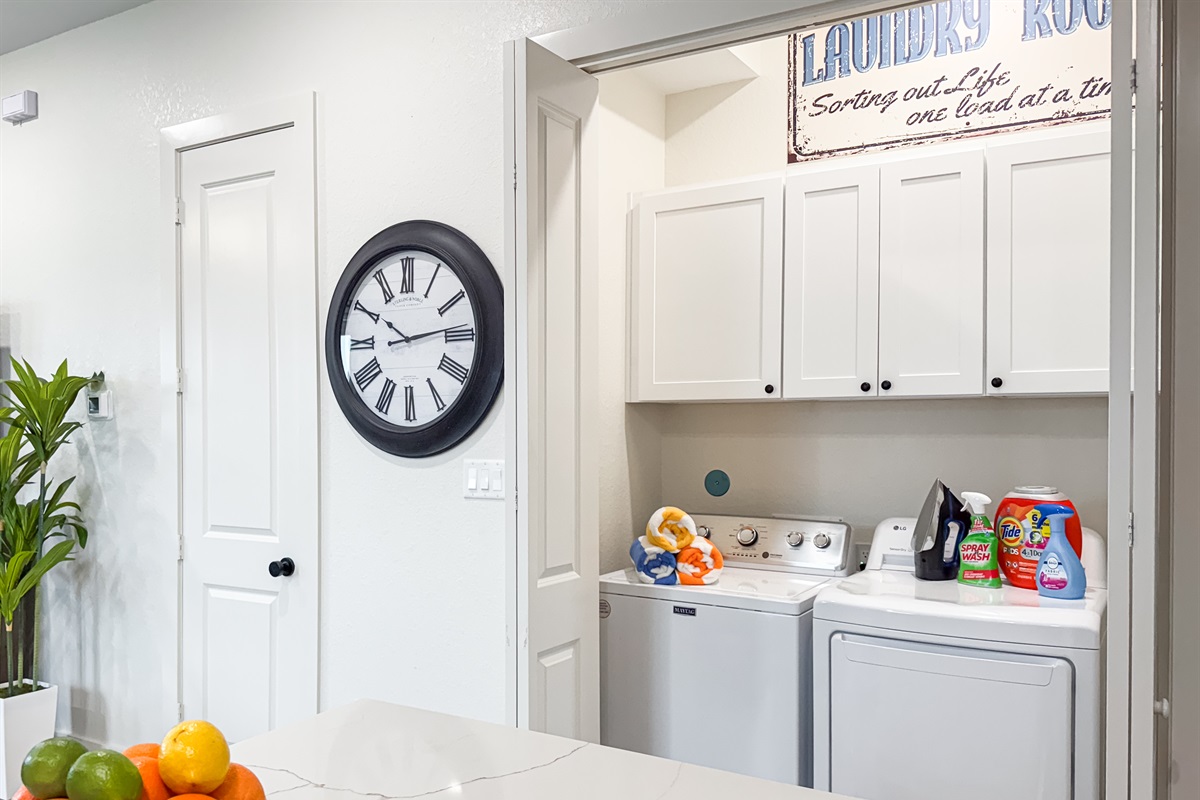 The laundry with a washer and dryer is located by the kitchen.