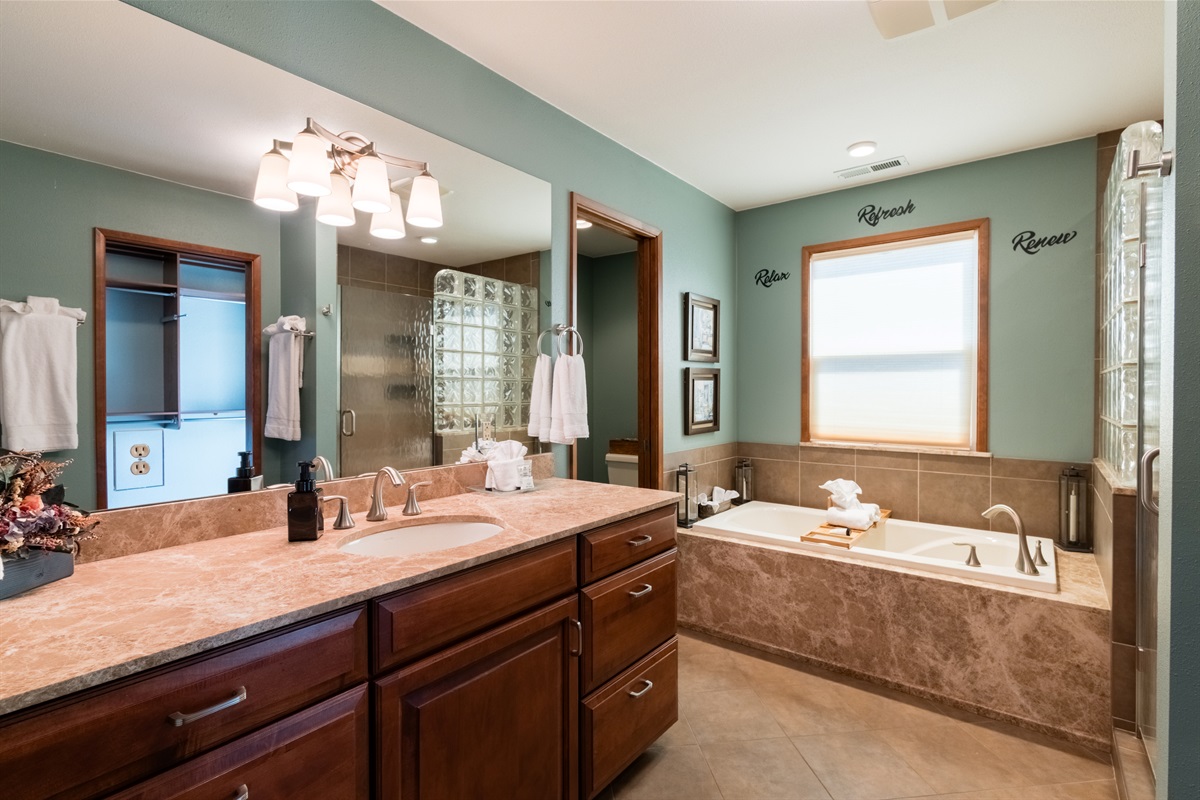 Master bathroom with towels and large bathtub.