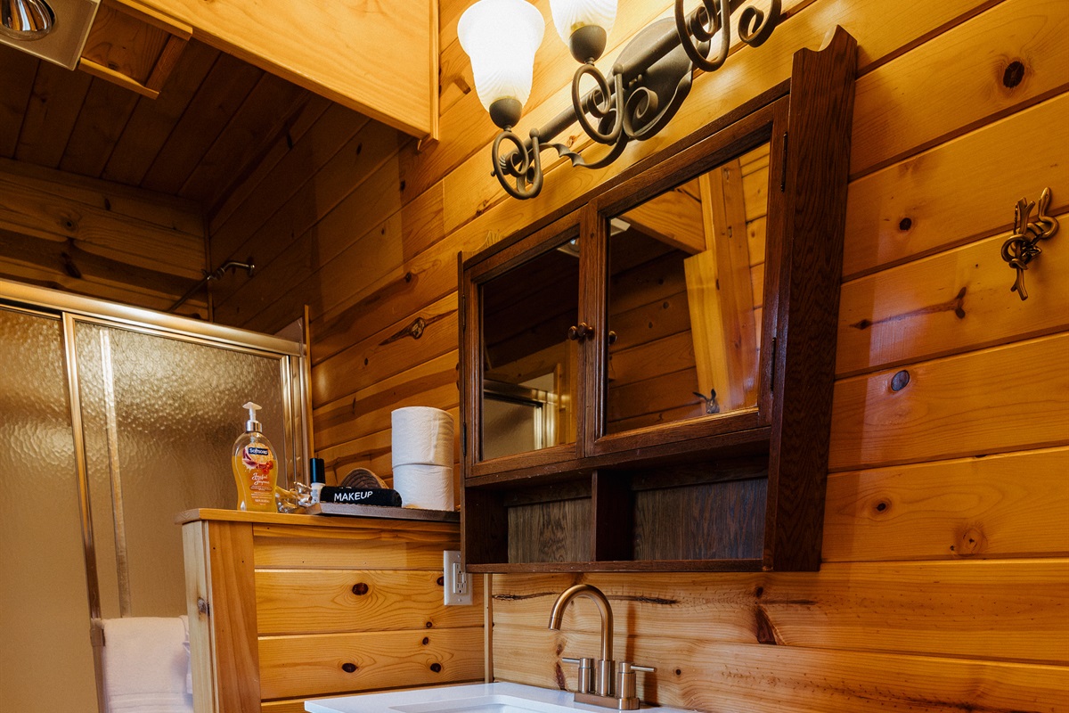 Poppywood Pines’ thoughtfully designed bathroom features generous counter space, ample storage, warm wood finishes, and a modern vanity—offering comfort and convenience for families and groups enjoying a relaxing White Mountains cabin getaway.