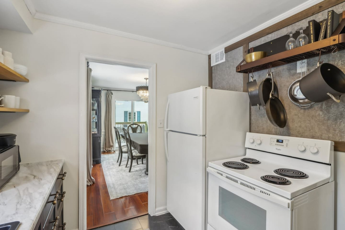 This kitchen keeps the essentials close at hand with a full-size refrigerator, stove, and easy access to the dining area.