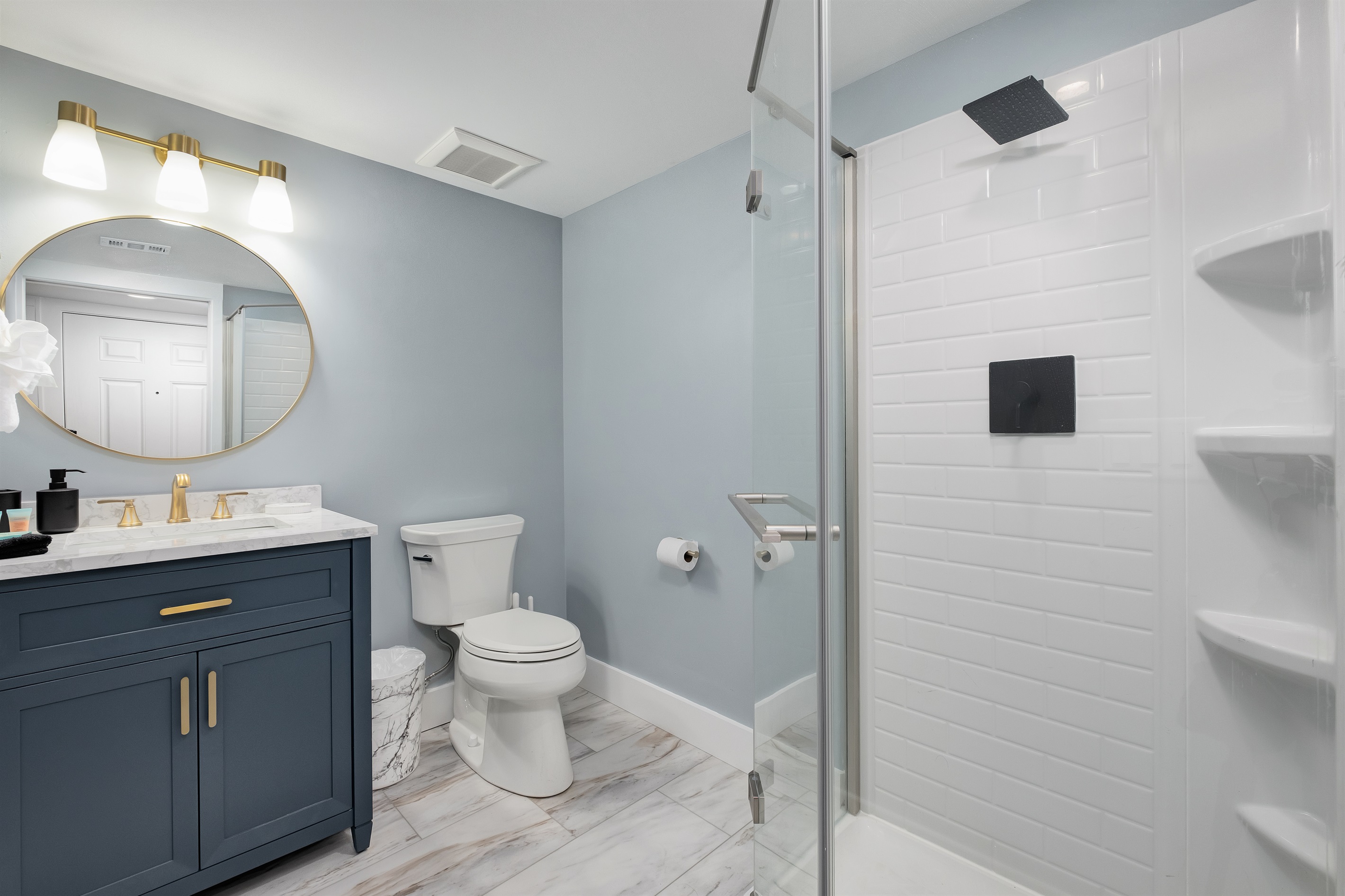 Relax in the modern bathroom featuring elegant finishes and a walk-in shower. A perfect retreat after a day at the beach.