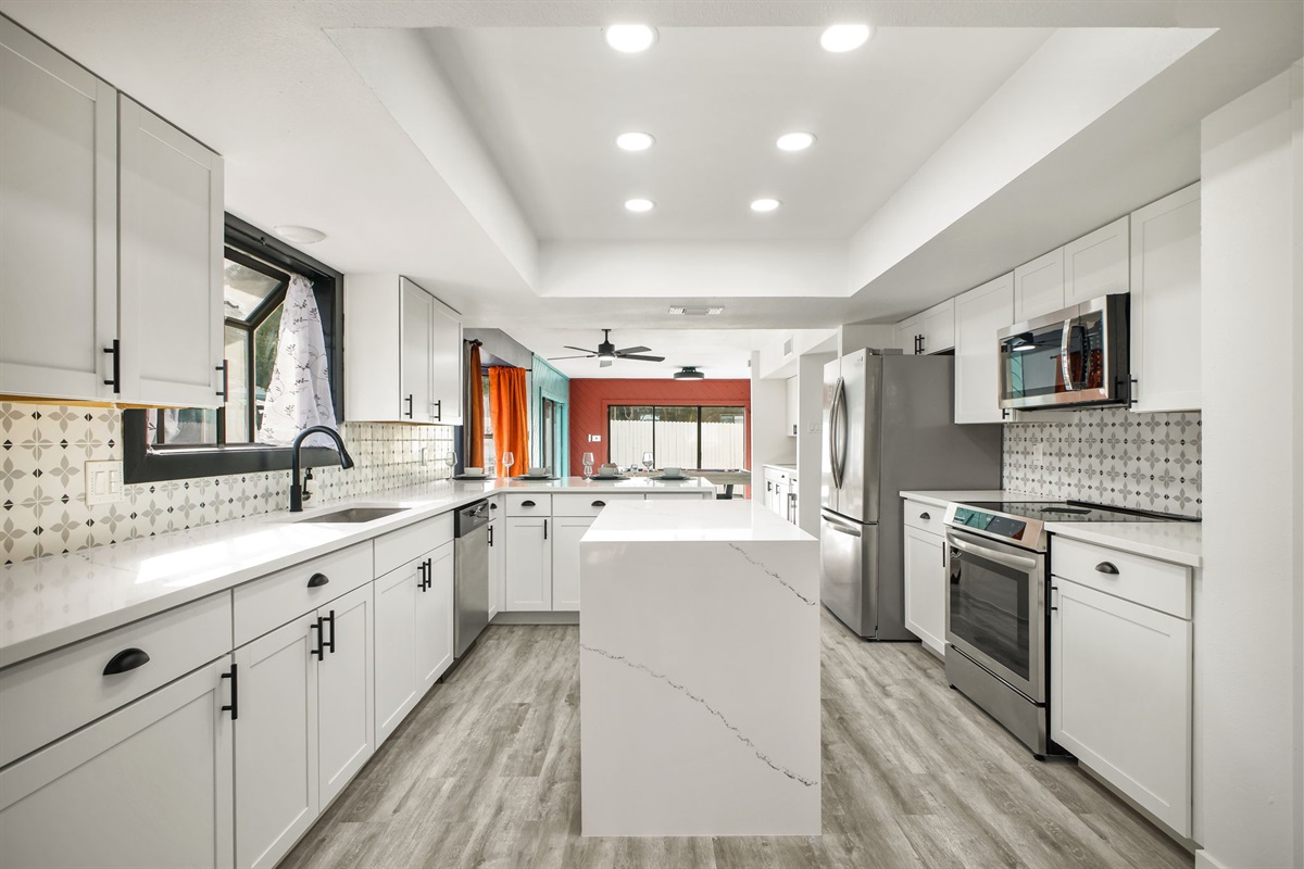 Full Kitchen: Bright open-concept kitchen with white cabinetry and quartz countertops. Southwest-inspired backsplash adds a stylish pop of design.