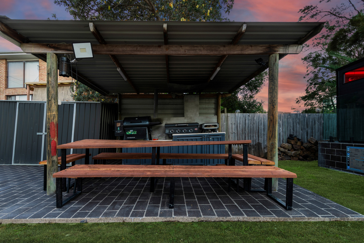 Skye’s Beach House includes a backyard BBQ area with smoker, gas pizza oven, seating and outdoor dining space.