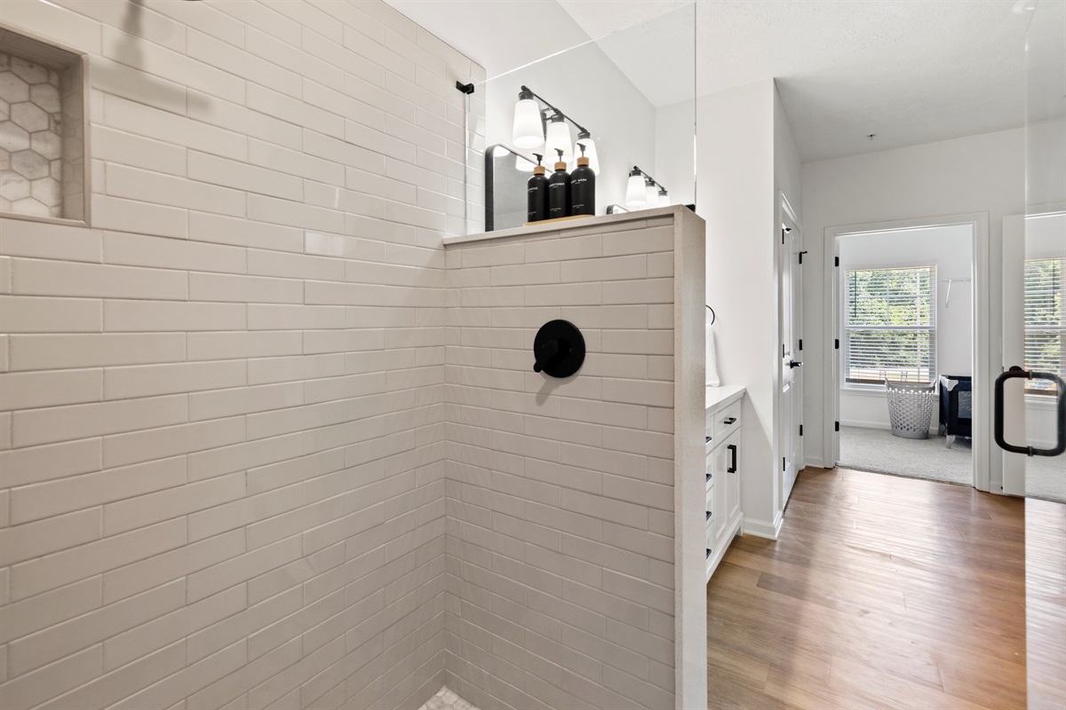 Spacious walk-in shower with glass doors.
